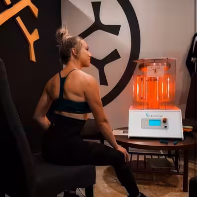 Young Woman in Black Shirt Sitting Next to the Working BioCharger Device