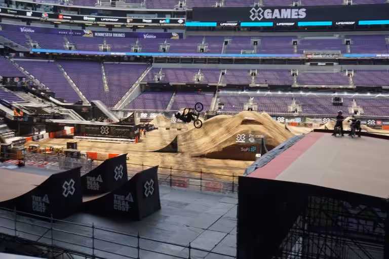 Man Performs a Flip on a BMX Bike in the Arena