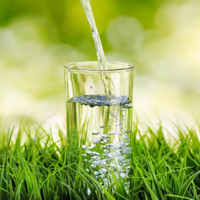 Water is Dripping into the Clear Glass that is Standing on the Grass