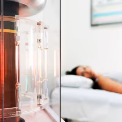 Woman Lying in a White Cozy Bed and Looking at the Working BioCharger Device