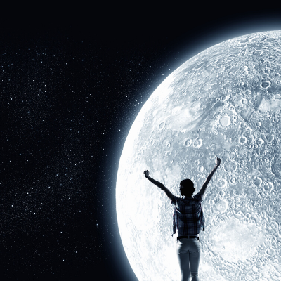 Close-Up of a Bright Moon in Dark Universe Behind a Person with Raised Hands