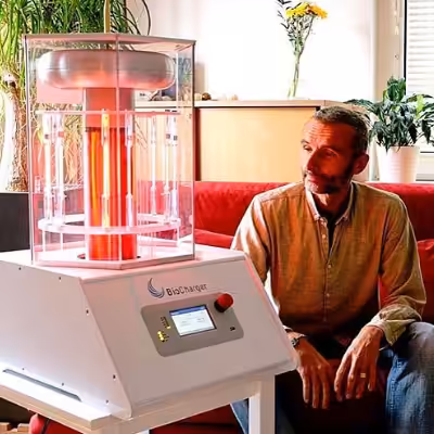 Man Sitting Smiling and Looking at the Working BioCharger Device