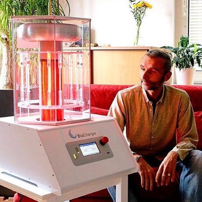 Man Sitting Smiling and Looking at the Working BioCharger Device