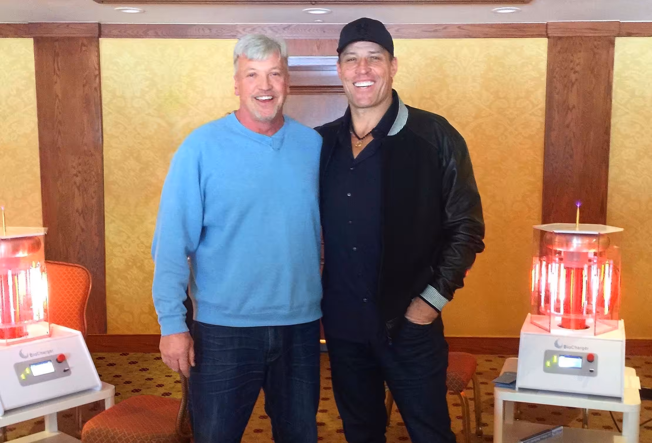 Jim Law CEO, Co-Founder of the BioCharger and Tony Robbins Standing Between Two Working BioCharger Devices and Smiling