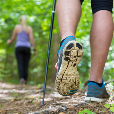 Male and Female Hiking with Hiking Sticks In the Woods