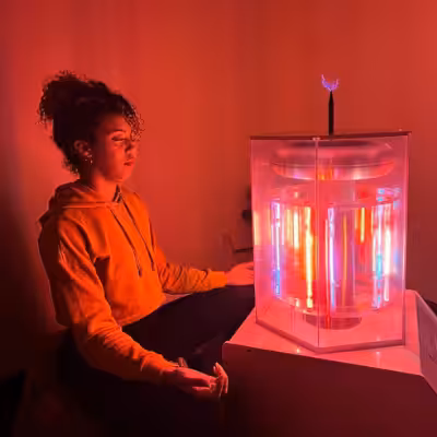 Woman Meditating Next to the Working BioCharger Device