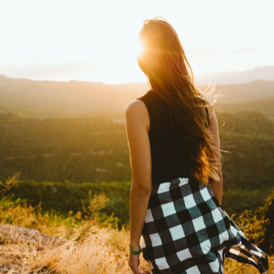 Young Woman in Black Shirt Standing And Watching the Mountains and Sun