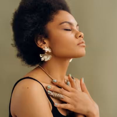 Woman in Black Shirt With Closed Eyes and Hands on Her Chest
