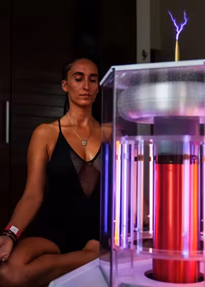 Woman Meditating Behind the Working BioCharger Device