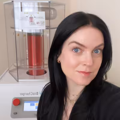 Beautiful brown-eyed woman in a black shirt in front of a BioCharger