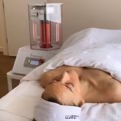 Women laying under a blanket on a treatment table while next to a bright BioCharger