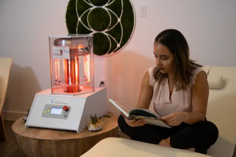 Woman Sitting Comfortably And Reading With the Activated BioCharger Device Next to Her
