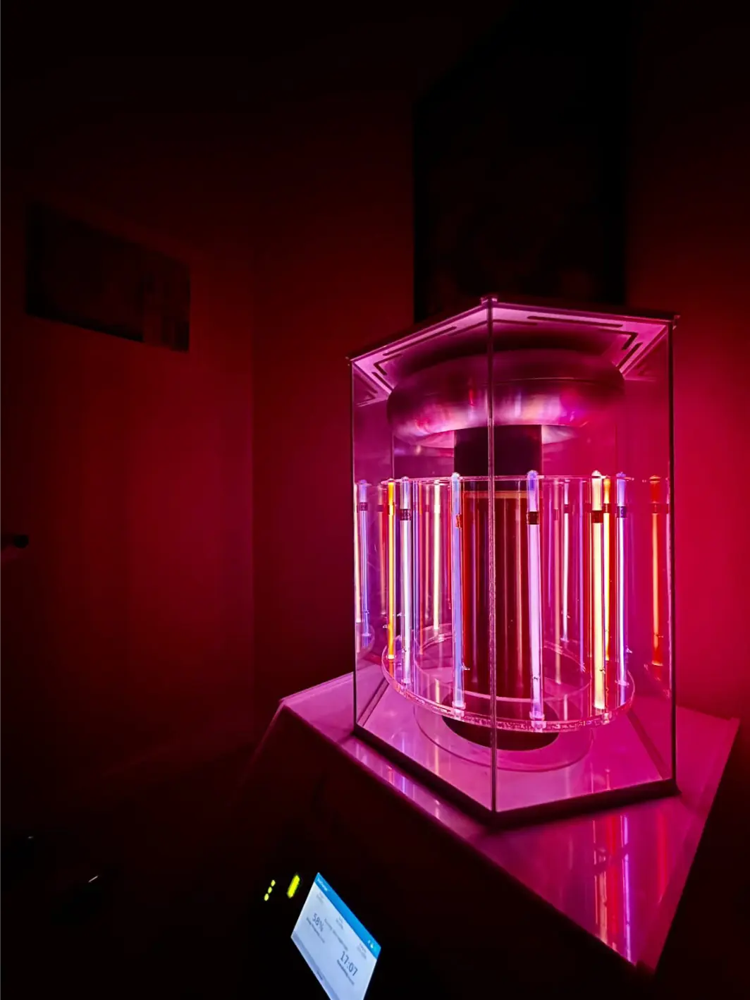 Pink, orange and red glowing BioCharger in a dark room