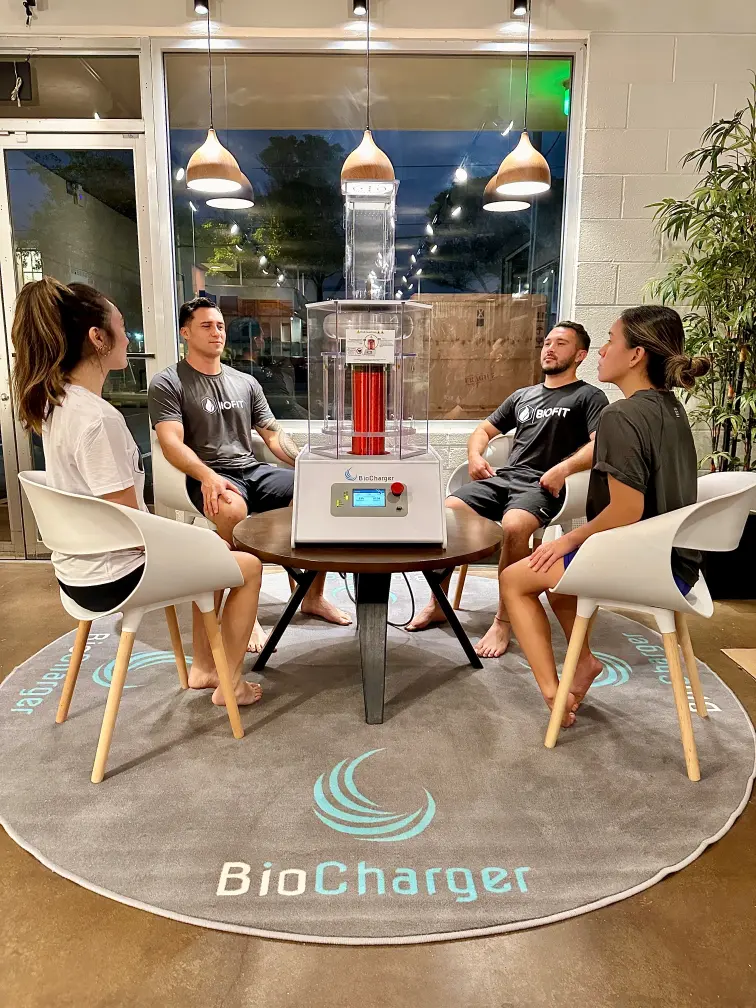 4 People sitting next to a biocharger.