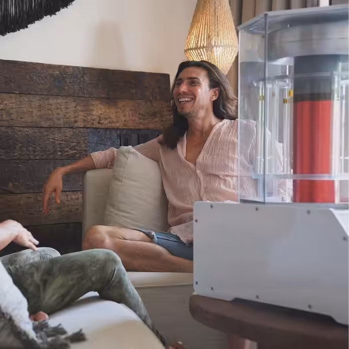 Young man sitting in a chair and smiling with a near by BioCharger table