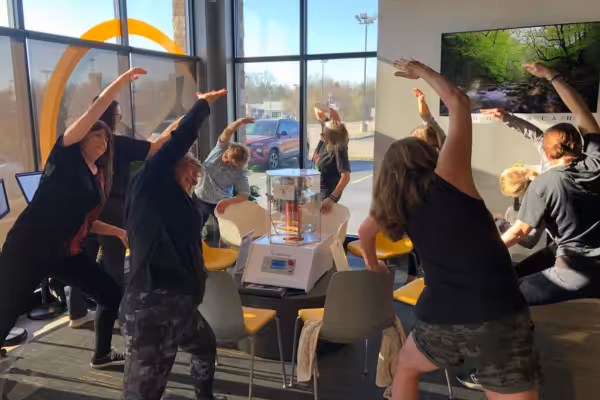 A group of women in athletic clothing participating in gentle stretching around the BioCharger
