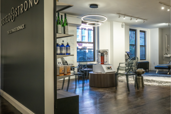 Wide angle shot of a OsteoStrong wellness space with the BioCharger and clear chairs as the focal point