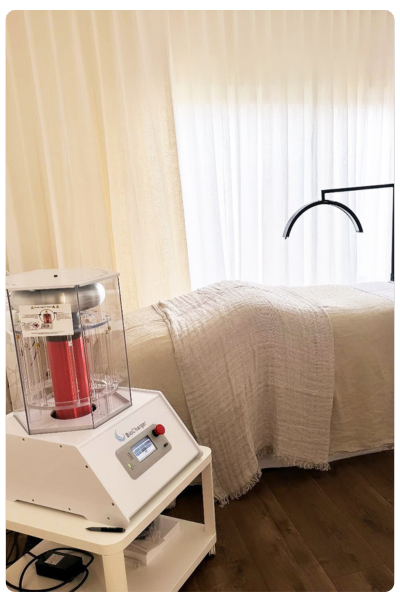 Fresh linen massage table in the background with the BioCharger in the forefront.